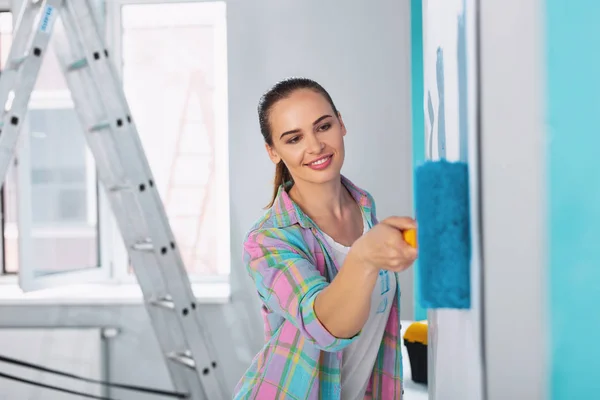 Sorrindo jovem pintando as paredes — Fotografia de Stock