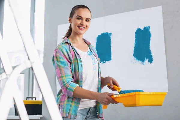 Cheerful girl doing some renovations in her flat — Stock Photo, Image