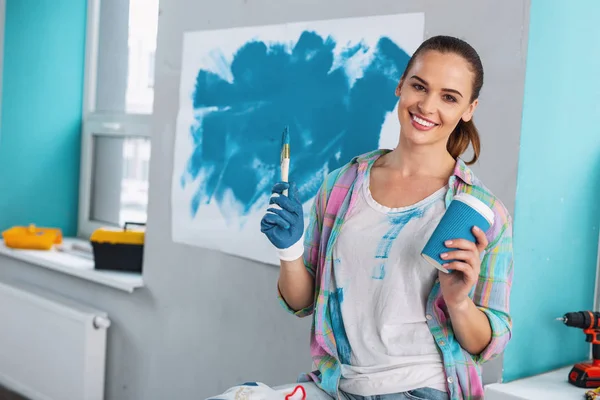 Happy woman holding a brush and coffee — Stock Photo, Image