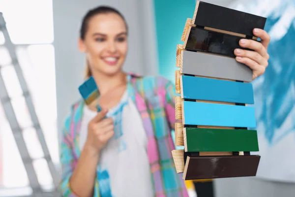 Mulher sorridente segurando uma paleta de cores — Fotografia de Stock