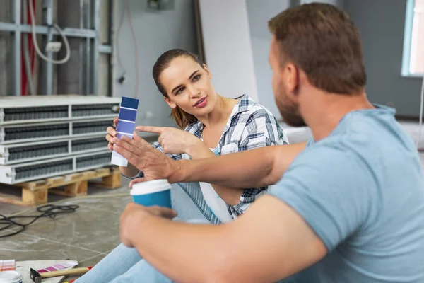 Glückliche Frau wählt Farben mit ihrem Mann — Stockfoto