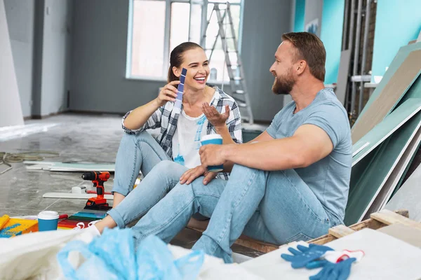 Überschwängliche Frau wählt Farben mit ihrem Mann — Stockfoto