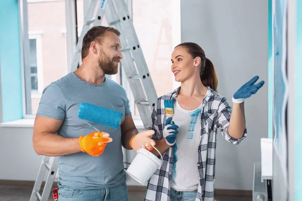 Pintores alegres discutiendo paredes de pintura — Foto de Stock