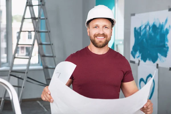 Construtor alegre segurando um grande esboço — Fotografia de Stock