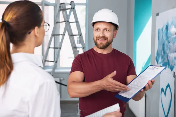 Щасливий будівельник, що показує контракт зі своїм клієнтом — стокове фото