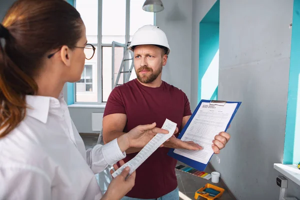 Allvarlig builder visar kontraktet till sin klient — Stockfoto