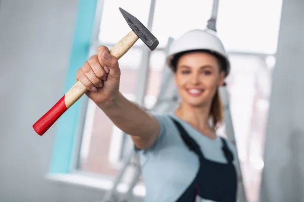 Joyful professional builder holding a hammer — Stock Photo, Image