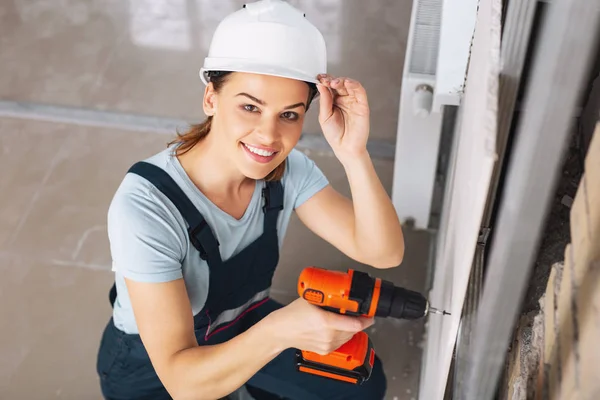 Constructora sonriente trabajando con un taladro —  Fotos de Stock