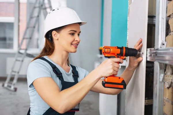 Inspired female builder working with a drill