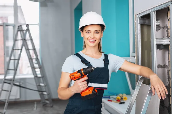 Cheerful skilled builder holding a drill — Stock Photo, Image