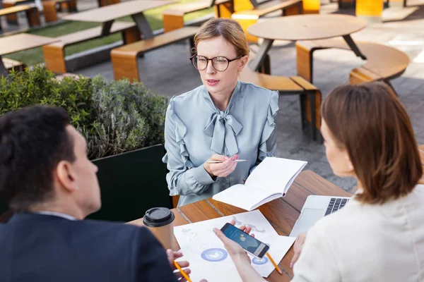 Elegante mujer de negocios con elegante blusa discutiendo proyecto —  Fotos de Stock