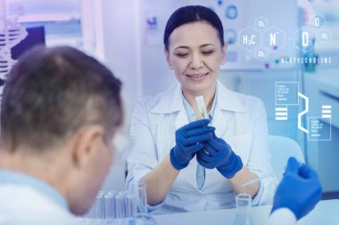 Sakin biyolog bir test tüpü içinde ot, bakarken gülümseyen