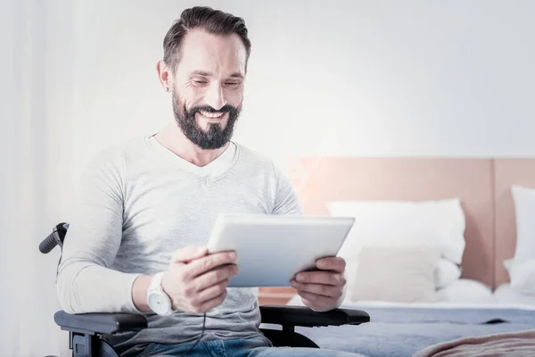 Homem aleijado sorrindo segurando um tablet — Fotografia de Stock