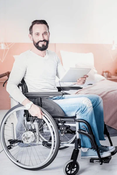 Homem aleijado exuberante segurando um tablet — Fotografia de Stock