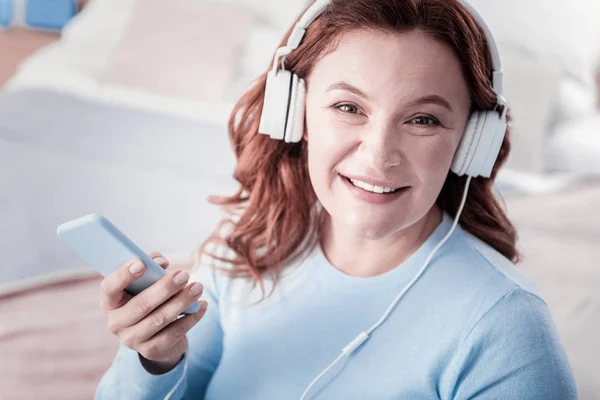 Sonriente mujer agradable escuchando música —  Fotos de Stock