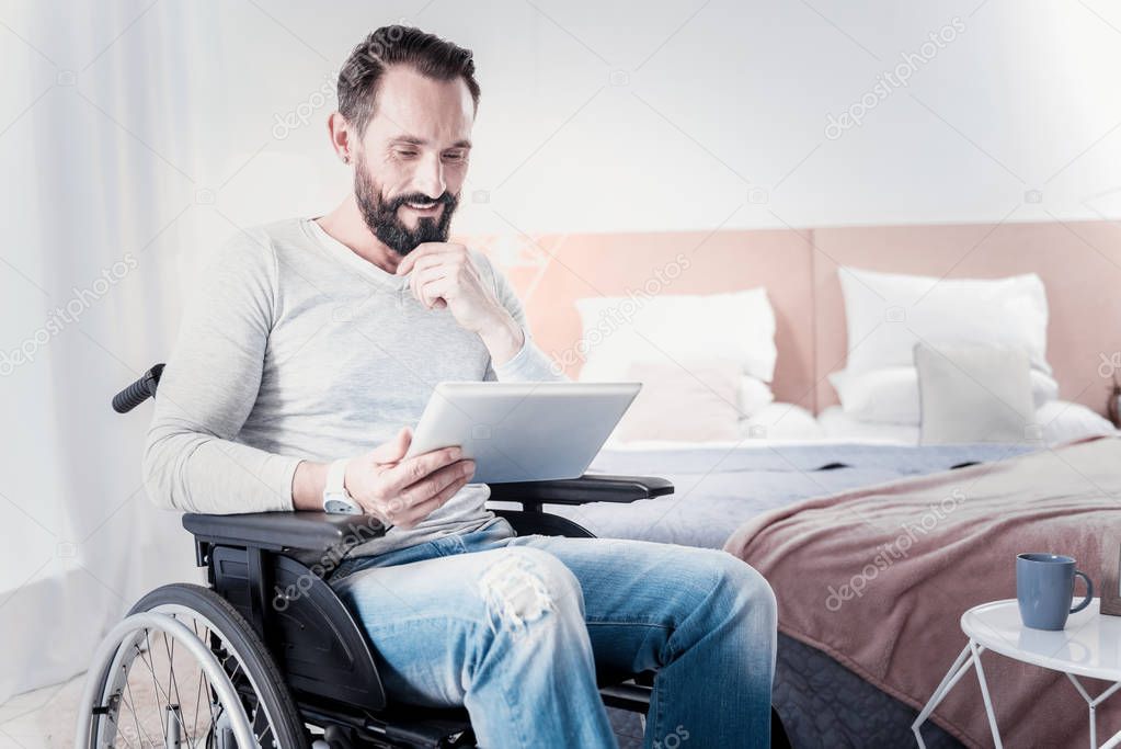 Alert crippled man holding a tablet
