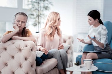 Üzgün kız uzakta iken annesi psikolog ile konuşurken arıyorsunuz