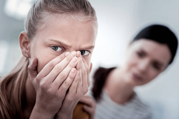 Закрыть лицо испуганной девушкой, закрывающей лицо руками
