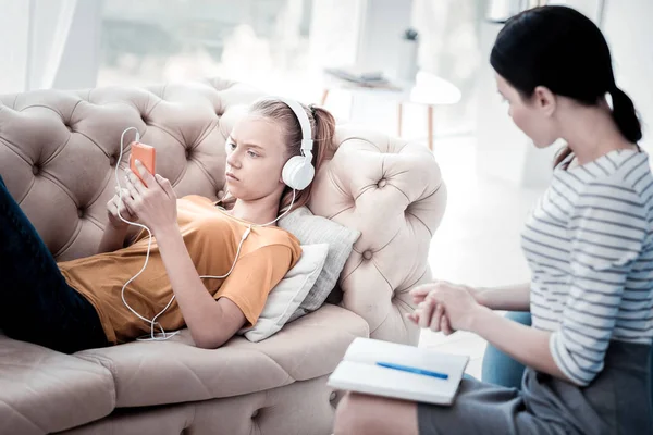 Upprörd tjej Lyssna på musik under behandlande psykolog — Stockfoto