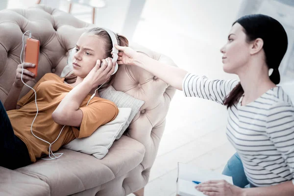 Ung psykolog med hörlurar från flickan — Stockfoto