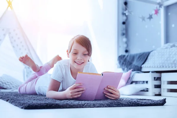 Feliz joven leyendo libro y sonriendo —  Fotos de Stock