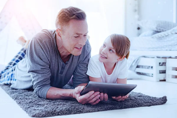 Ojciec i córka z komputera typu tablet, leżąc na podłodze — Zdjęcie stockowe