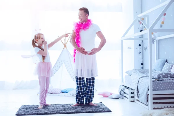 Дочка сміється над татом, роблячи вигляд балерини — стокове фото