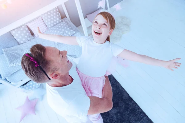 Menina extremamente feliz brincando com o pai em casa — Fotografia de Stock