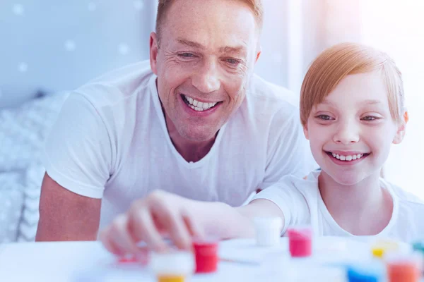 Opgewonden vader en dochter op zoek naar kleurrijke verf — Stockfoto