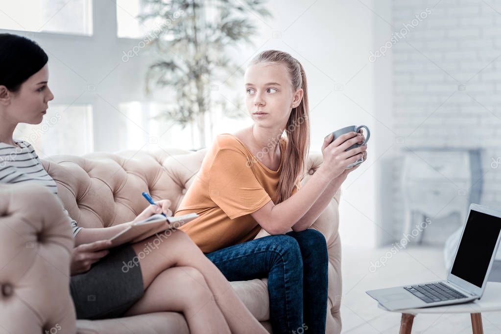 Attentive girl looking at psychologist