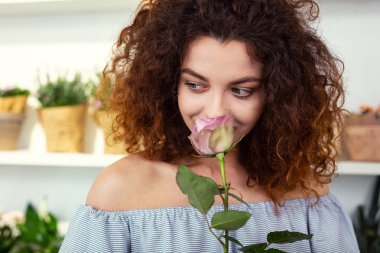Nice attractive woman smelling a rose clipart