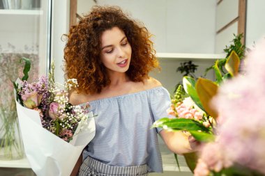 Çiçeklere bakarak mutlu güzel kadın