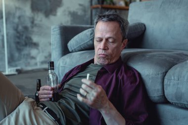 Sigara elinde tutan adam alkol bağımlısı