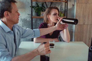 Genç kadın alkollü şarap şişesinden içiyor