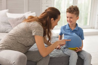Eğlenceli evlat. Çekici esmer hamile bekliyor kadın küçük oğlu eğlenceli iken son derece mutlu hissediyor