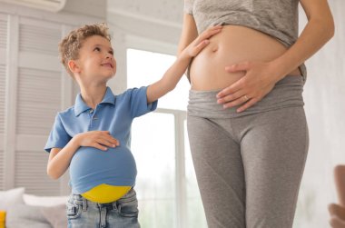 Meraklı küçük oğlu bekliyor annesi karnını dokunmadan