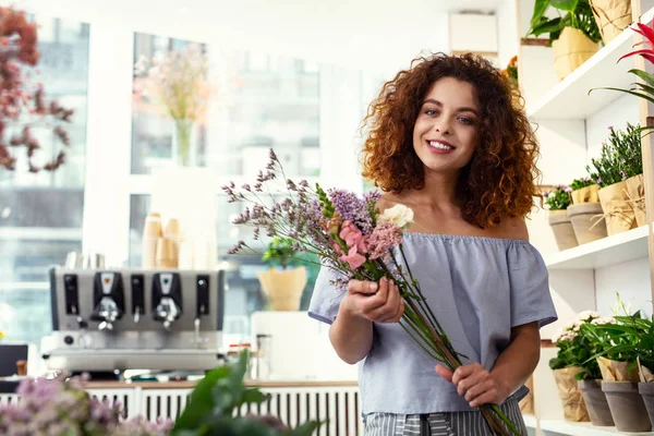 Gioiosa donna magnetica che tiene i fiori — Foto Stock