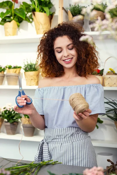 Mujer positiva encantada mirando la bobina de la cuerda — Foto de Stock