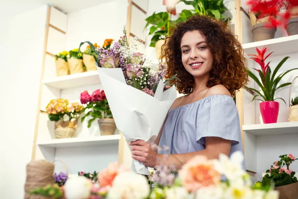 Bir buket tutan neşeli çekici kadın