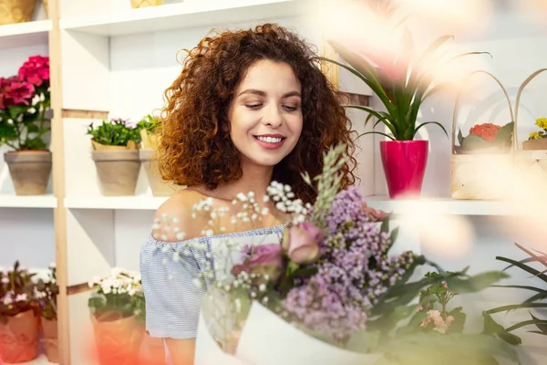 Çiçekler arasında duran neşeli mutlu kadın