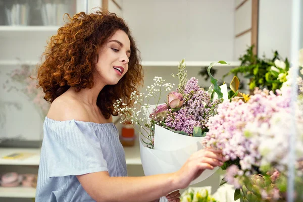 Milá příjemná žena dotýká květiny — Stock fotografie