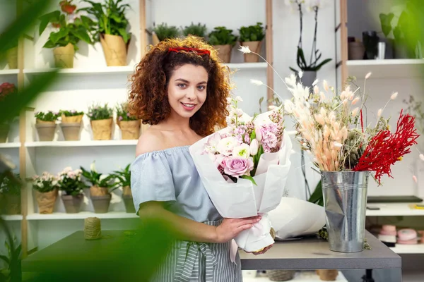 Delighted nice woman visiting flower shop