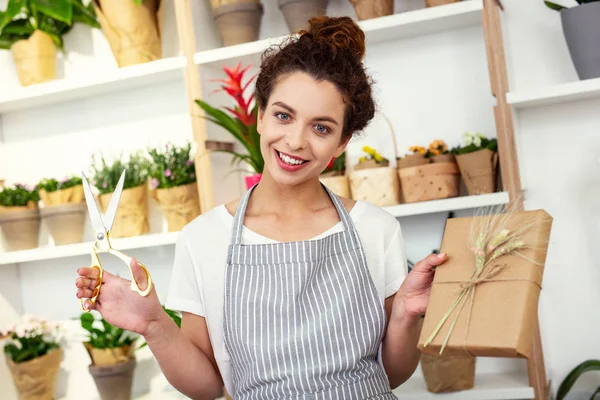 Feliz mujer positiva empujándote una caja de regalo — Foto de Stock