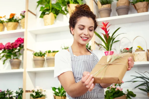 Mujer positiva encantada mirando la caja de regalo — Foto de Stock