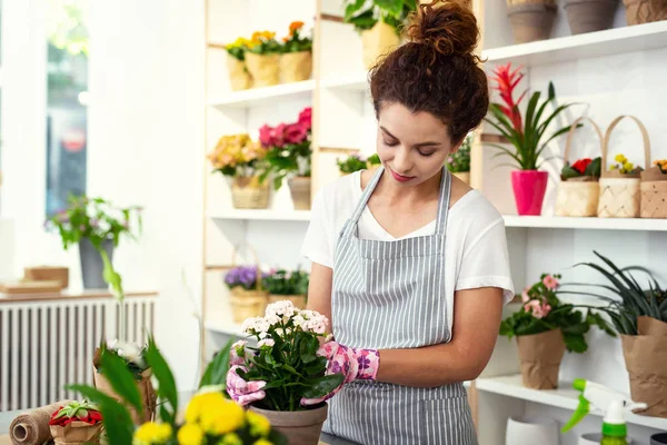 Mooie jonge vrouw die kijken naar de bloem — Stockfoto