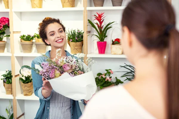 Encantada mujer agradable que ofrece ramo — Foto de Stock