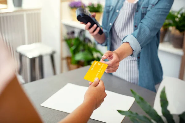 Assistente de loja profissional levando um cartão de crédito — Fotografia de Stock