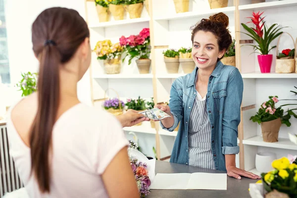 Asistente de tienda encantado tomando un pago — Foto de Stock