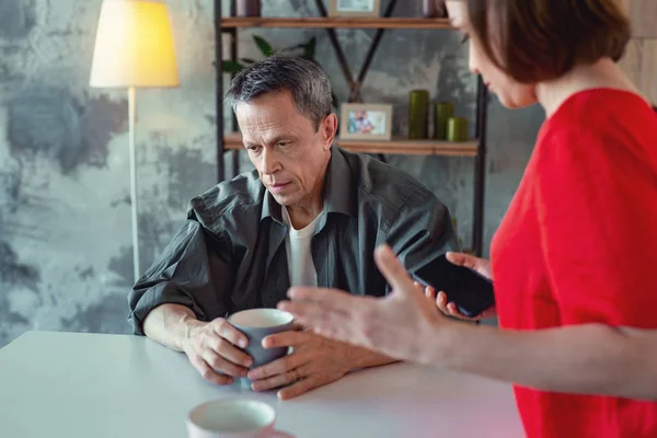 Sad mature man listening to his young wife — Stock Photo, Image