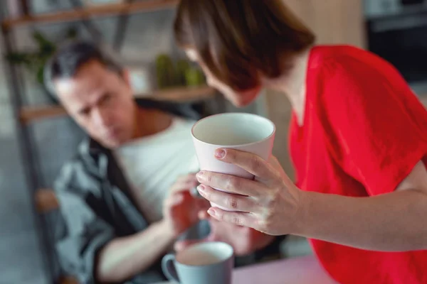 Dark-haired vrouw roze glas staande te houden in de keuken — Stockfoto